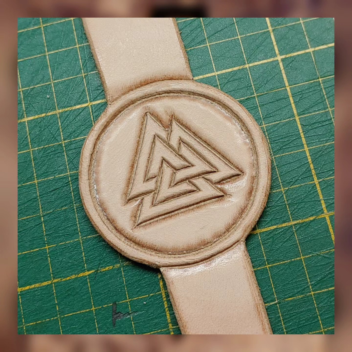 Detail: von Hand punzierter Valknut in pflanzlich gegerbtem Leder